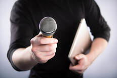 Picture of someone holding a microphone out to you